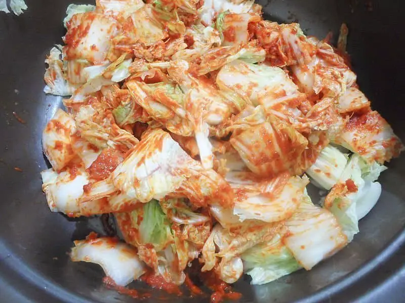 Toss the drained cabbage leaves in the red paste, making sure everything is well covered.