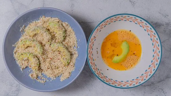 Dip each avocado wedge into the egg mixture, then place in the dish withthe parmesan breading mixture.