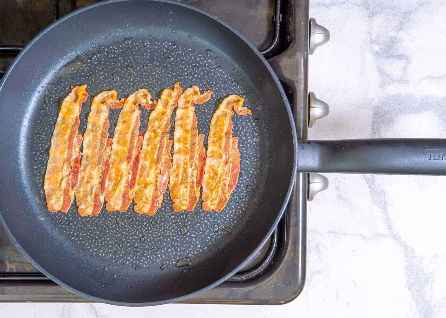 cook the bacon until it is cooked through and crispy